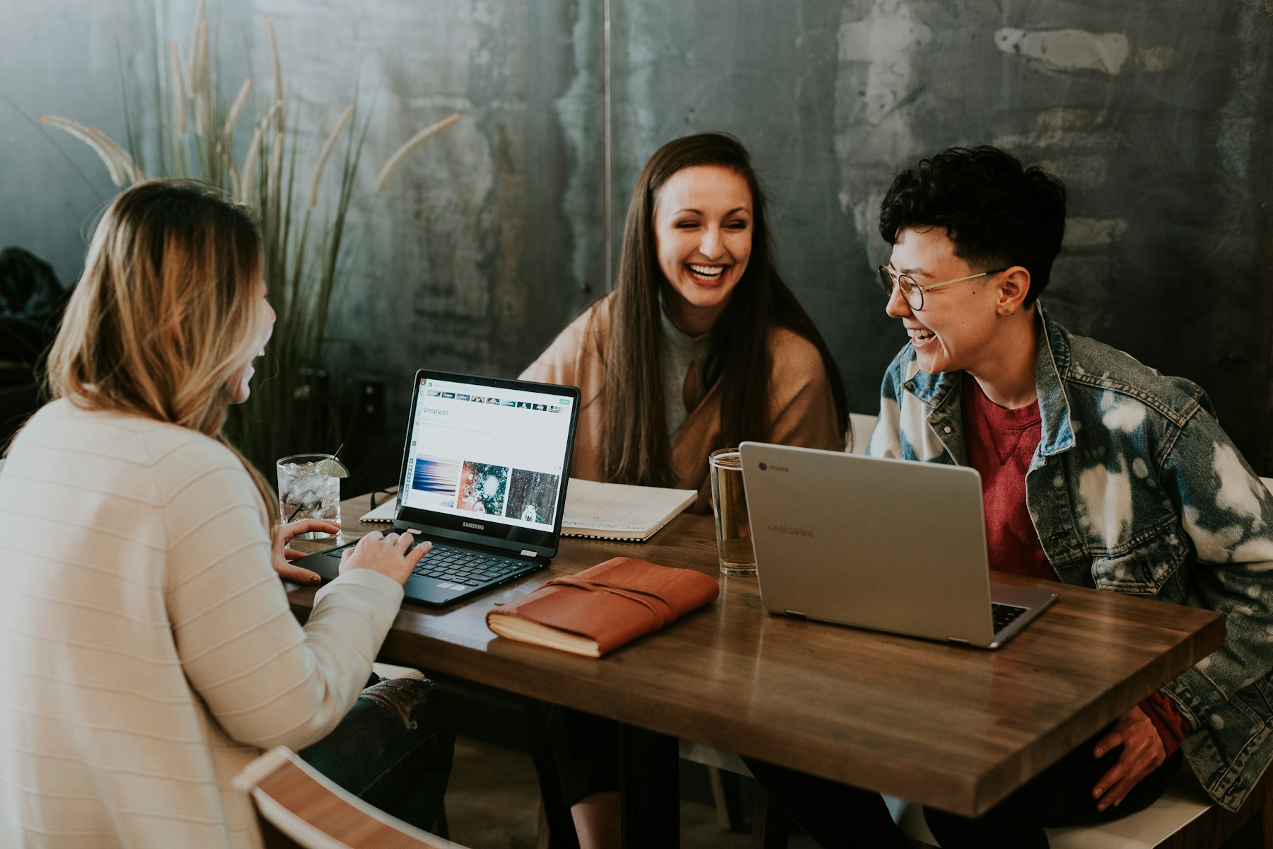 People working together on laptops at a wooden table